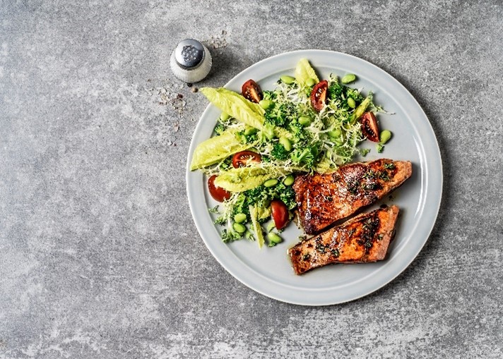 Photo of top view of cooked salmon steaks with a side of salad